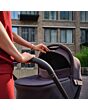 1518099110_F7_2026_maxicosi_stroller_oxfordcarrycot_oaktruffle_lifestyle_momcheckingcarrycot